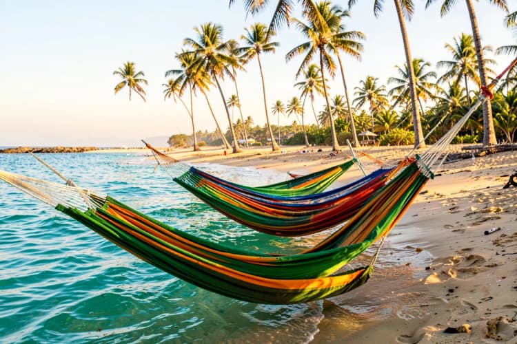 Pessoas relaxando em redes coloridas sobre a água calma e cristalina de uma lagoa em Jericoacoara.
